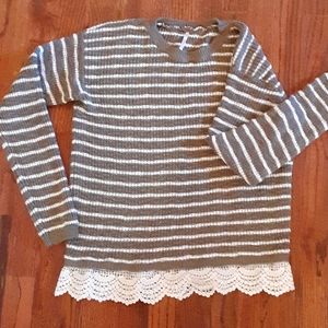 Longsleved sweater with crocheted material on end.